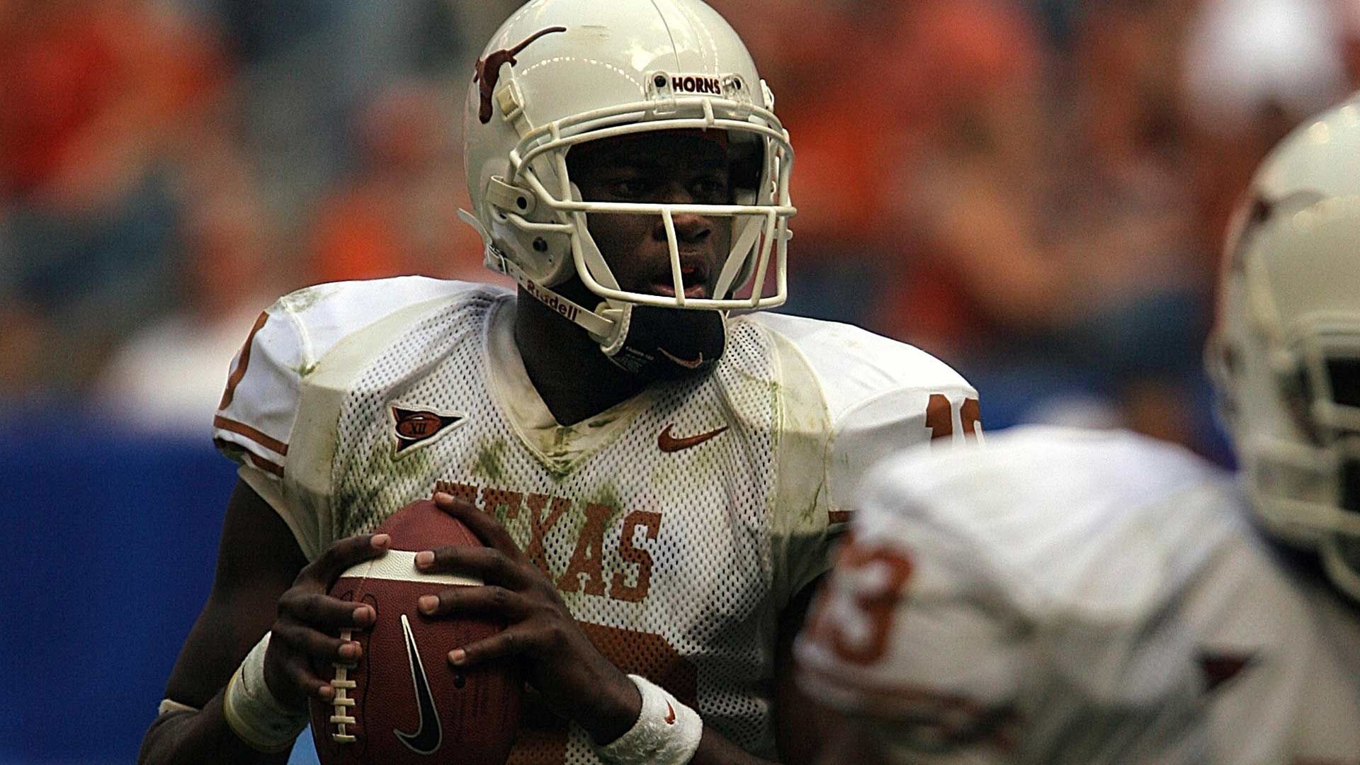 Photo of a college team quarterback about to throw the ball.